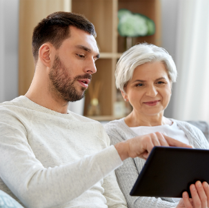 Grandson showing Grandmother something on a tablet device